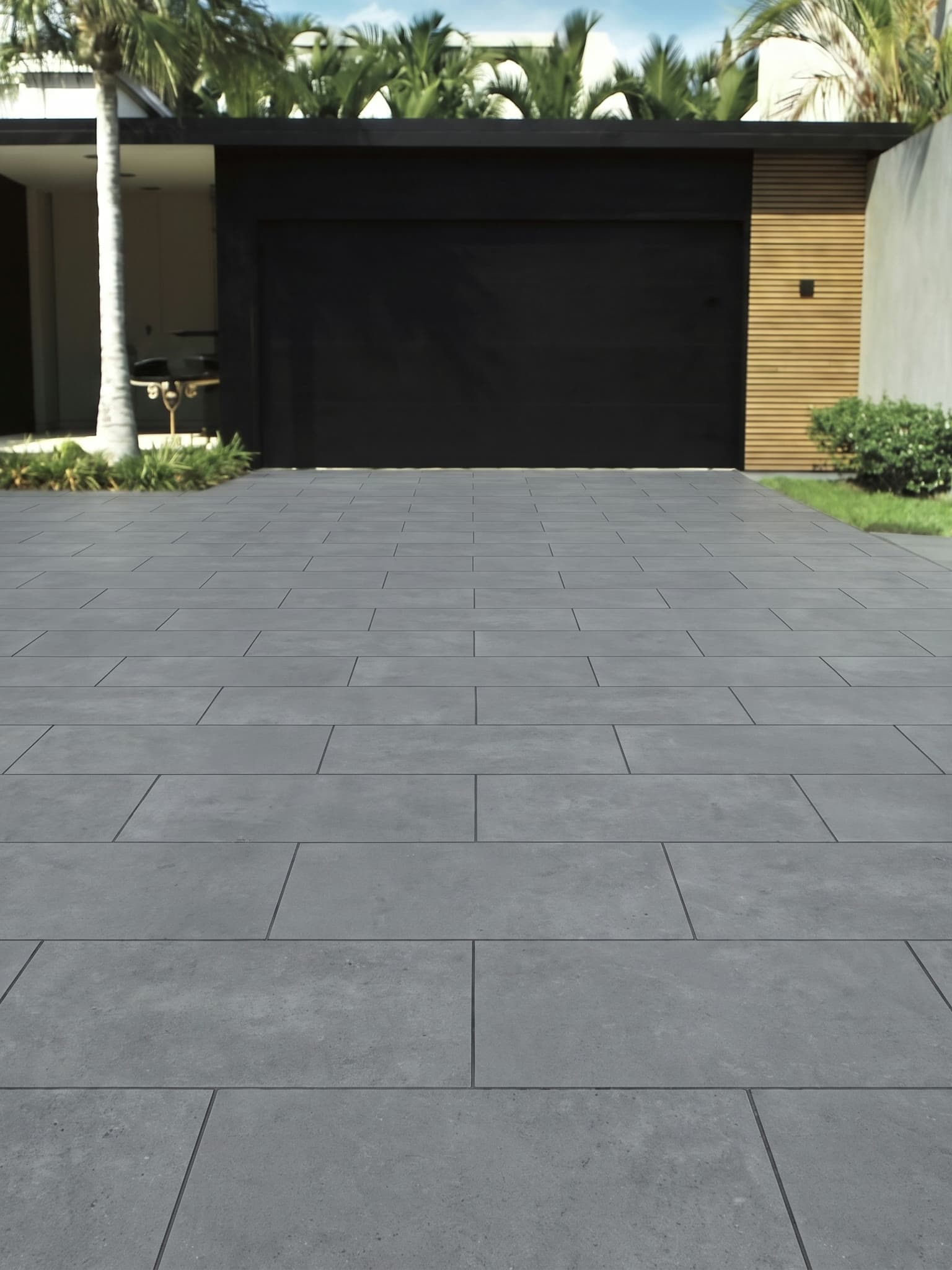 Driveway paved in 20mm sintered stone pavers in color 6705, a mid grey concrete look