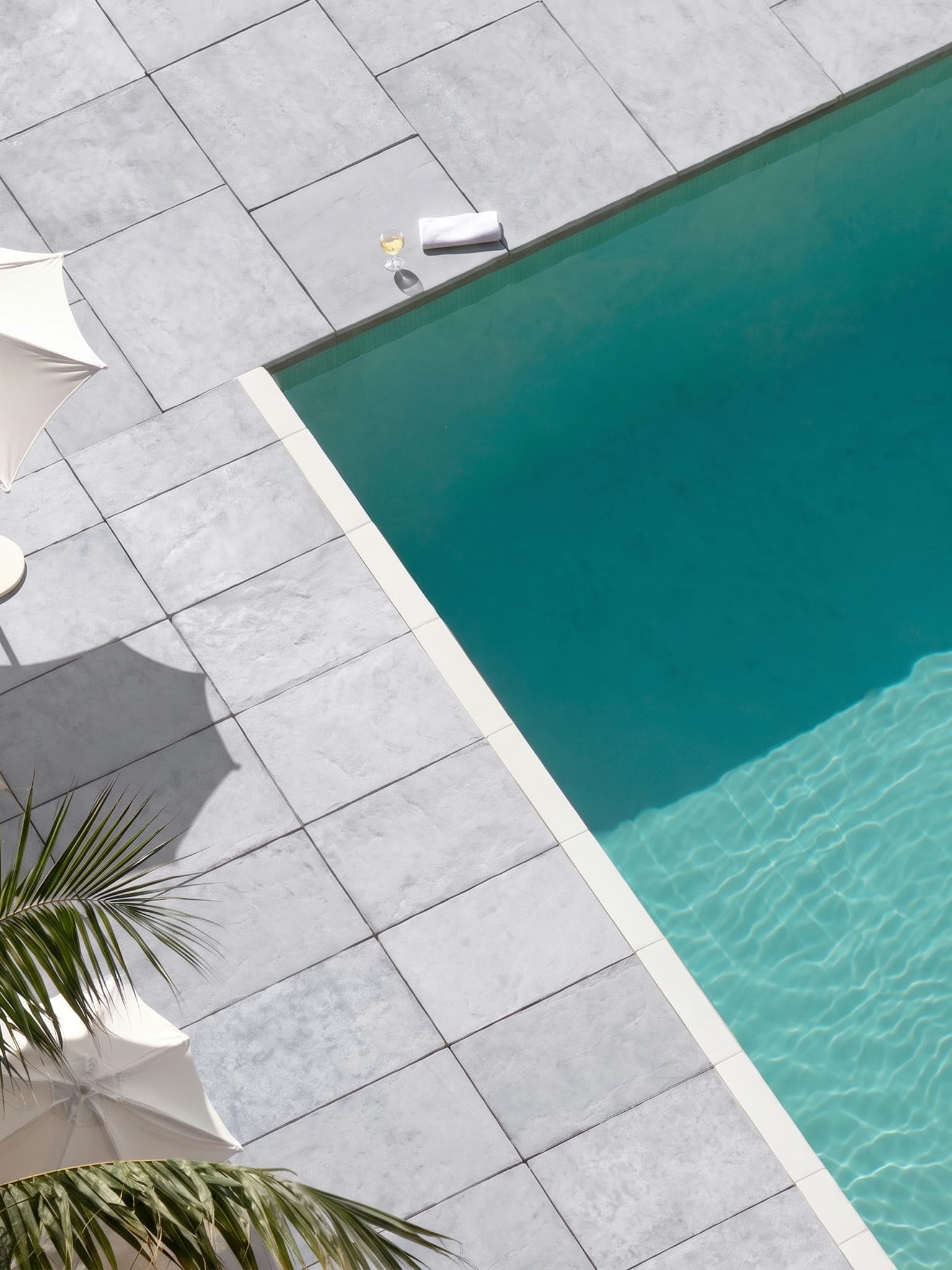 Pool deck finished in 20mm sintered stone pavers in color 6709, a light silver grey
